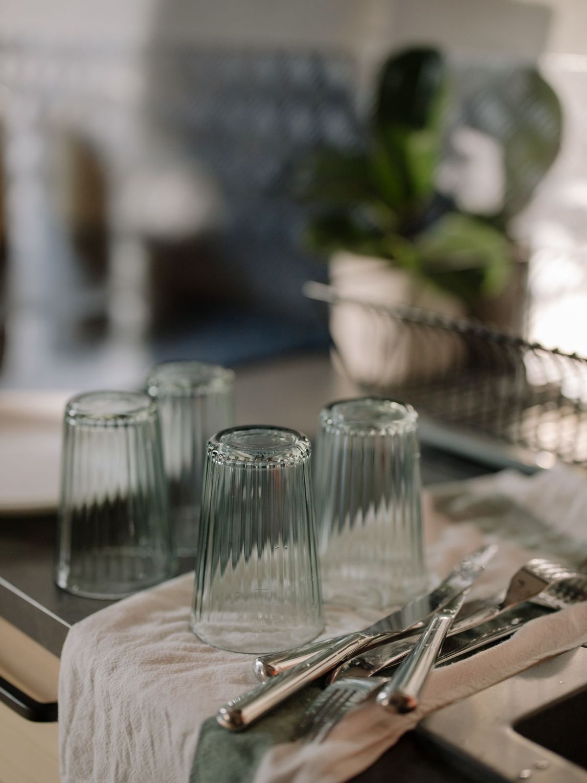 Clean drinking glasses drying on a fresh kitchen towel