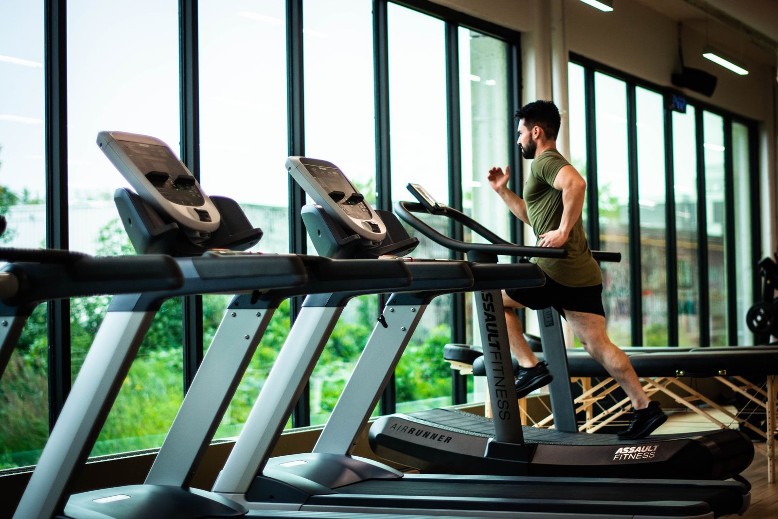 Row of treadmills by the windows of a fitness club