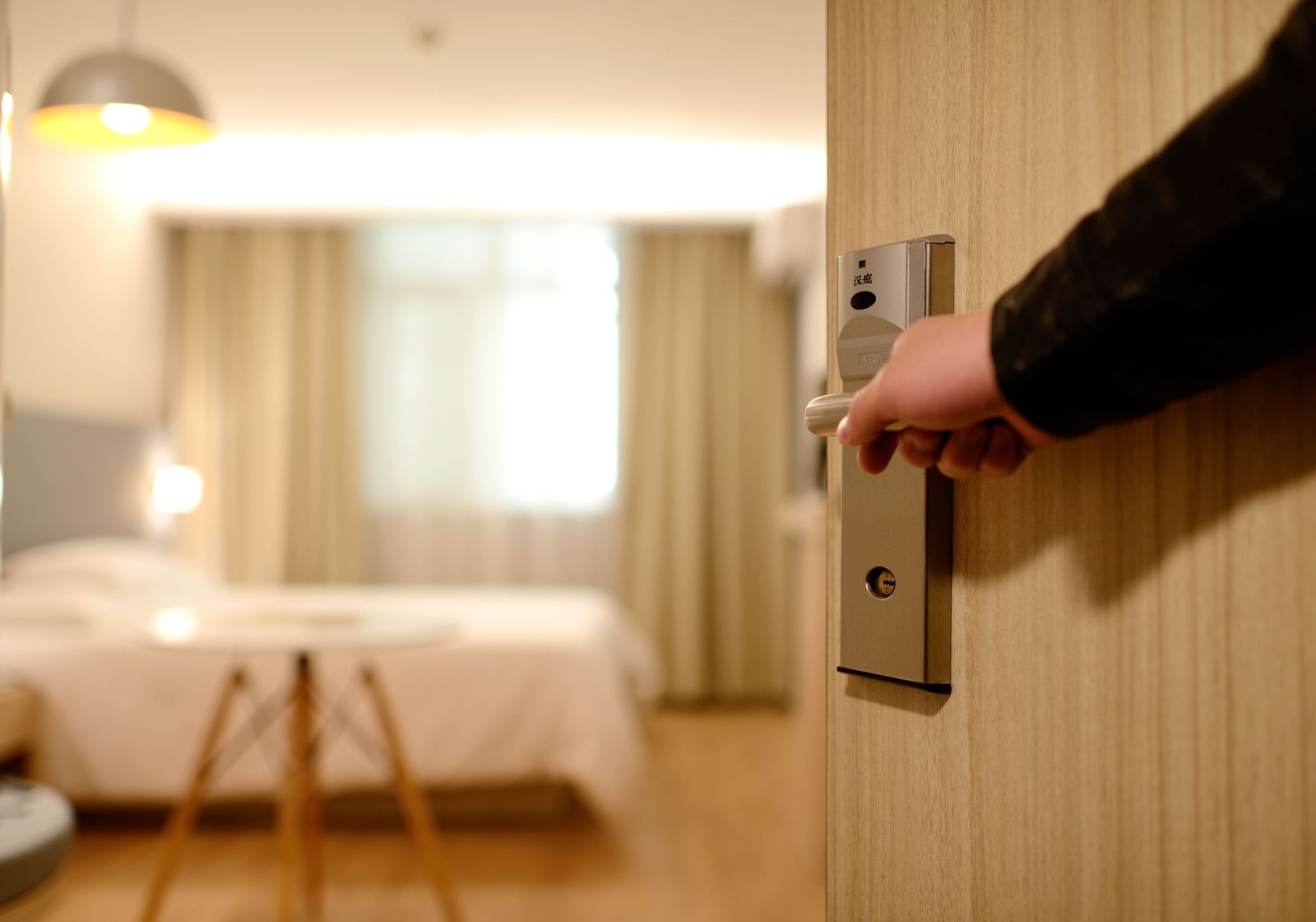 Guest entering a tidy hotel room with keycard in hand